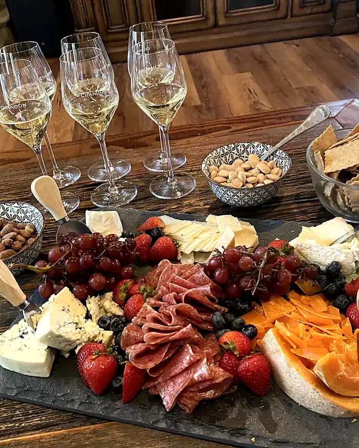 Champagne poured and waiting beside a grazing board at the start of an evening